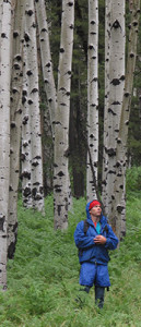 Author Tyler Williams standing in an aspen grove