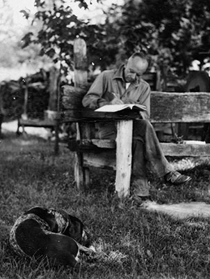 Aldo Leopold writing at his shack with his dog, Flick.