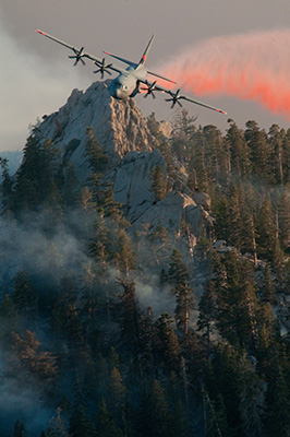 A National Guard aircraft rops retardant over trees as part of the response to the 2013 Mountain Fire 