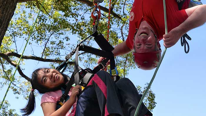 John Gathright helps a young tree climber discover her potential.