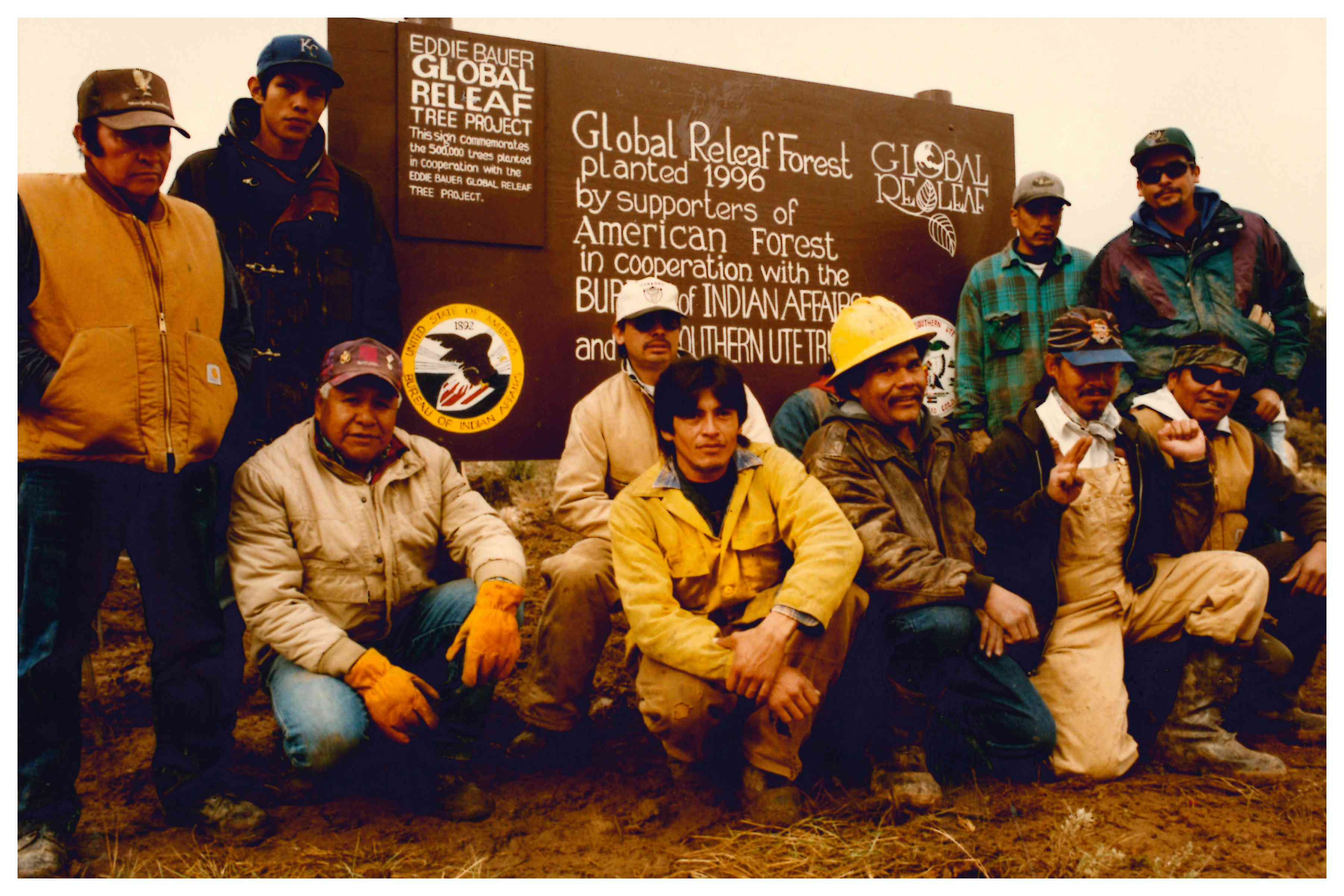 Ute men posing in front of commemorative Global ReLeaf sign 