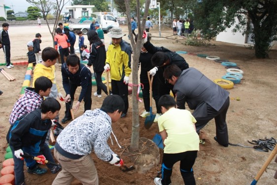 Students and teachers helping plant trees at HaCheon Elementary School in Changwon, South Korea.