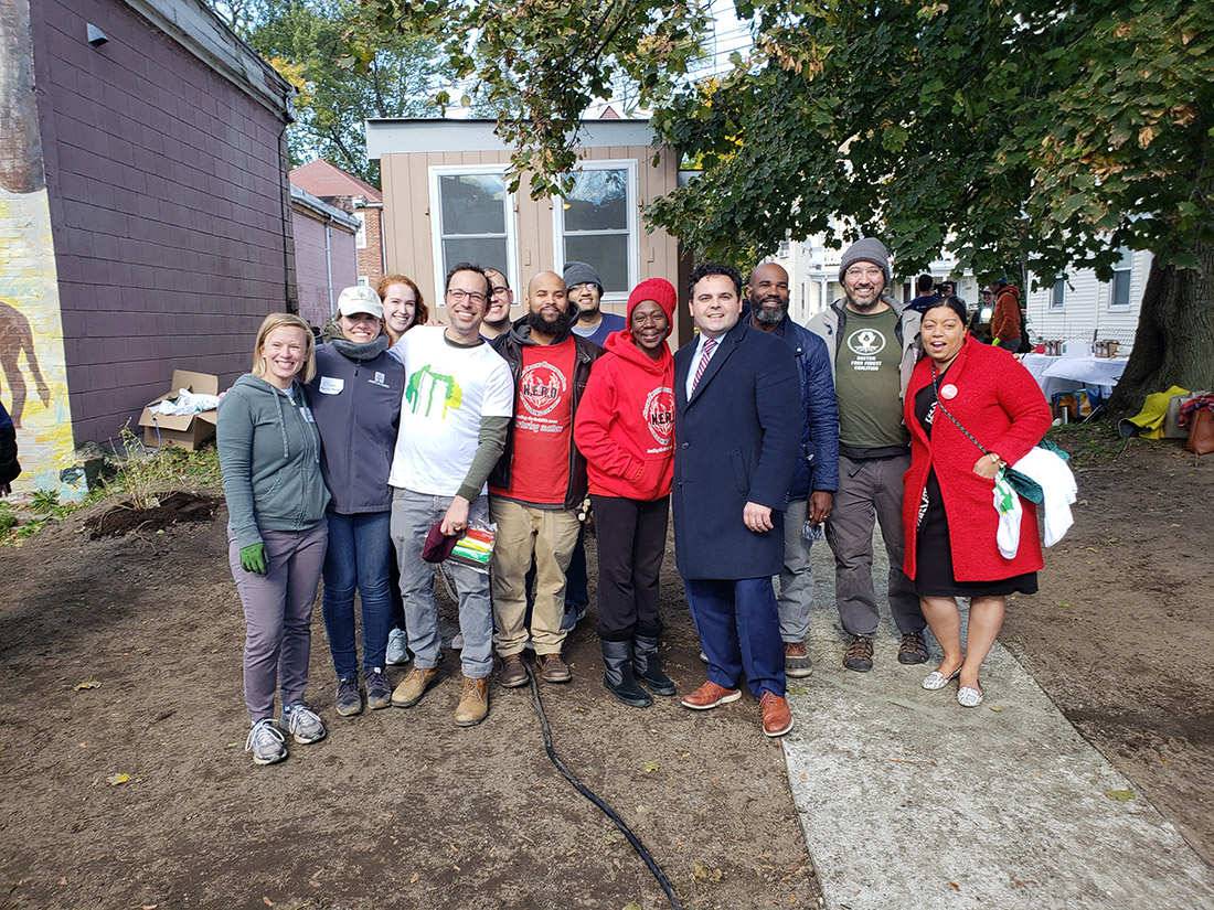 Mass. State Senator Nick Collins (navy coat) and Representative Liz Miranda (red coat) joined H.E.R.O. Hope Garden founder Judith Foster (red hat) and the team to install the new garden in Dorchester.