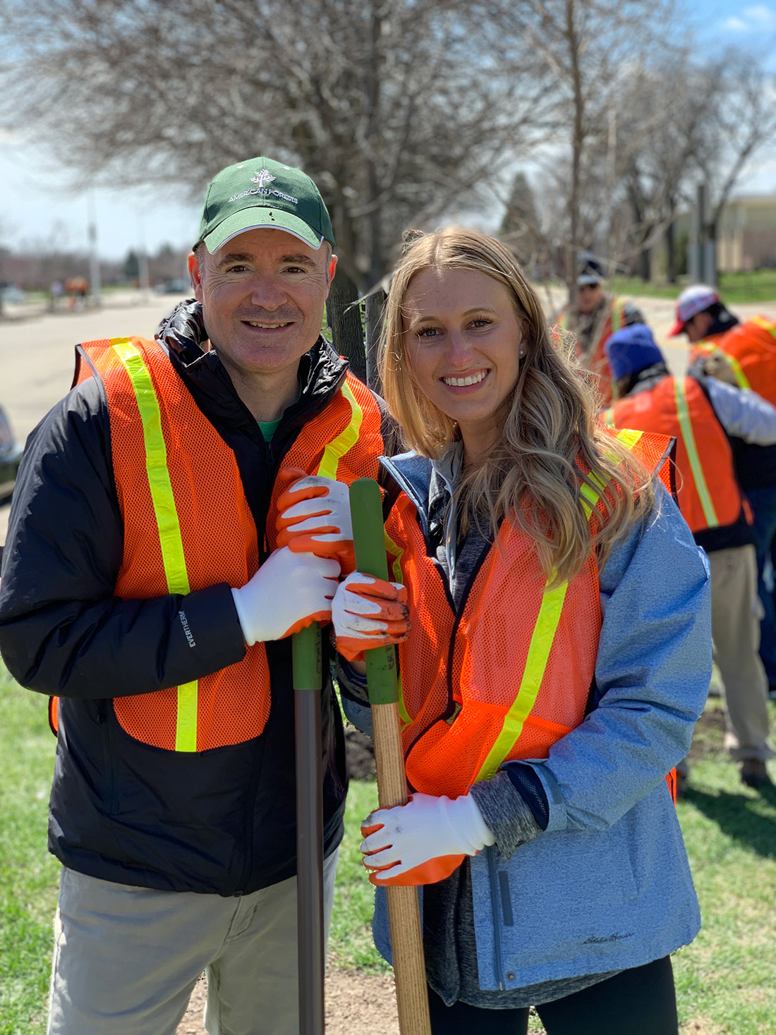 Jad Daley, president and CEO of American Forests, and Daniela Lukomski, marketing manager at Eddie Bauer, pose next to a newly planted tree in Skokie, Ill.