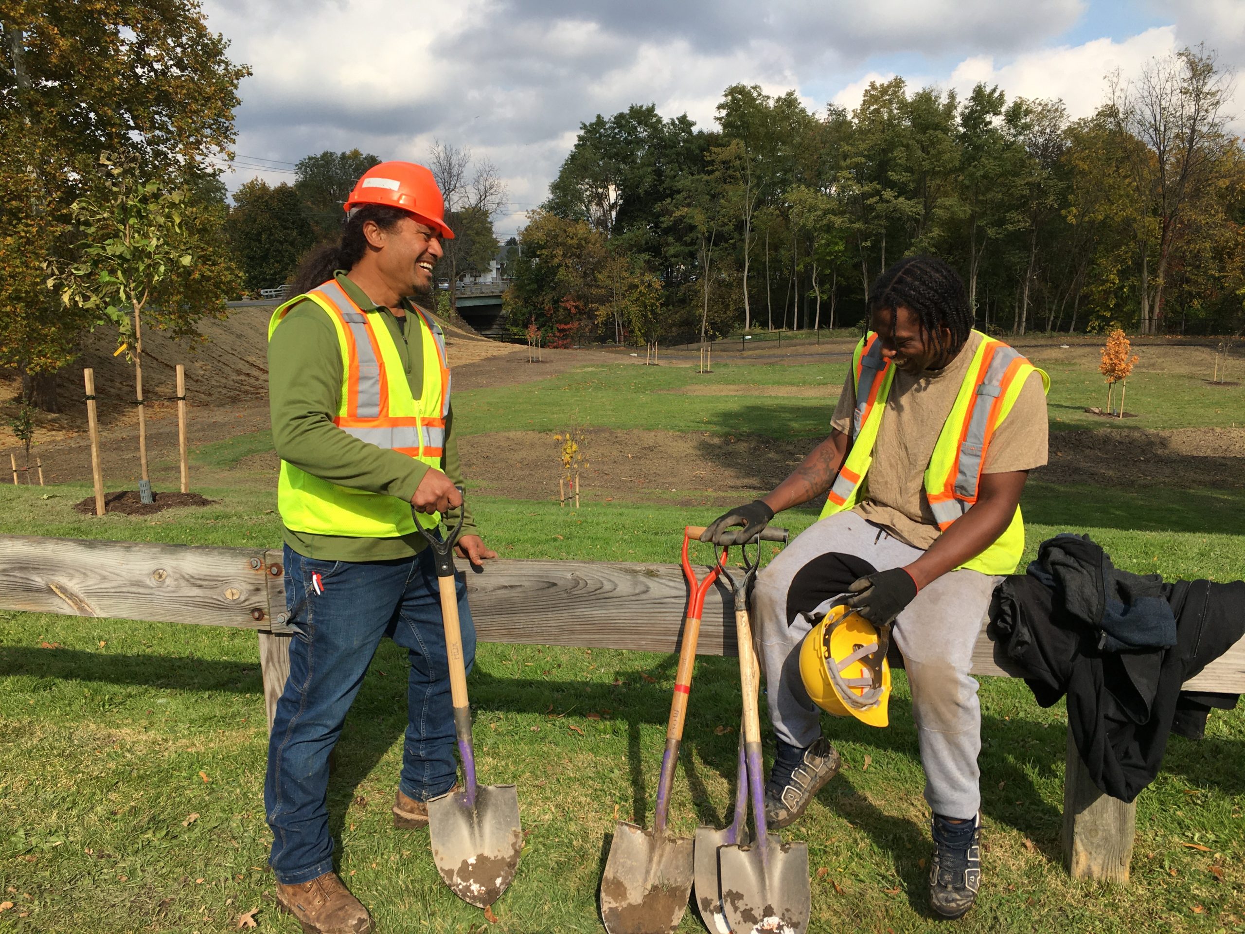 Ioane Etuale (left), a graduate of the Onondaga Earth Corps and tree care entrepreneur, and Rubin Harrison (right), Advanced Young Adult Crew member, catch up at a fall tree planting in Syracuse, N.Y.'s Kirk Park.