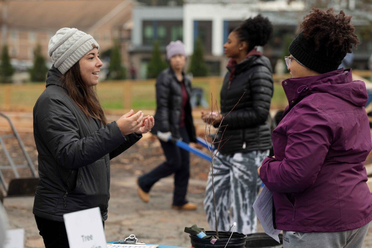 Hannah Schultz, program director for Georgia Interfaith Power and Light, speaks with a local resident at a community tree adoption event.