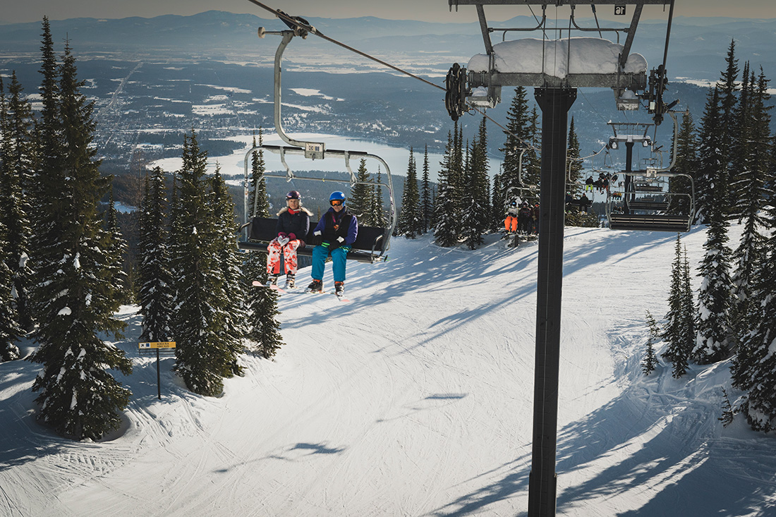 Skiers enjoy the abundant snow that whitebark pine trees help to retain at The Whitefish Mountain Resort.