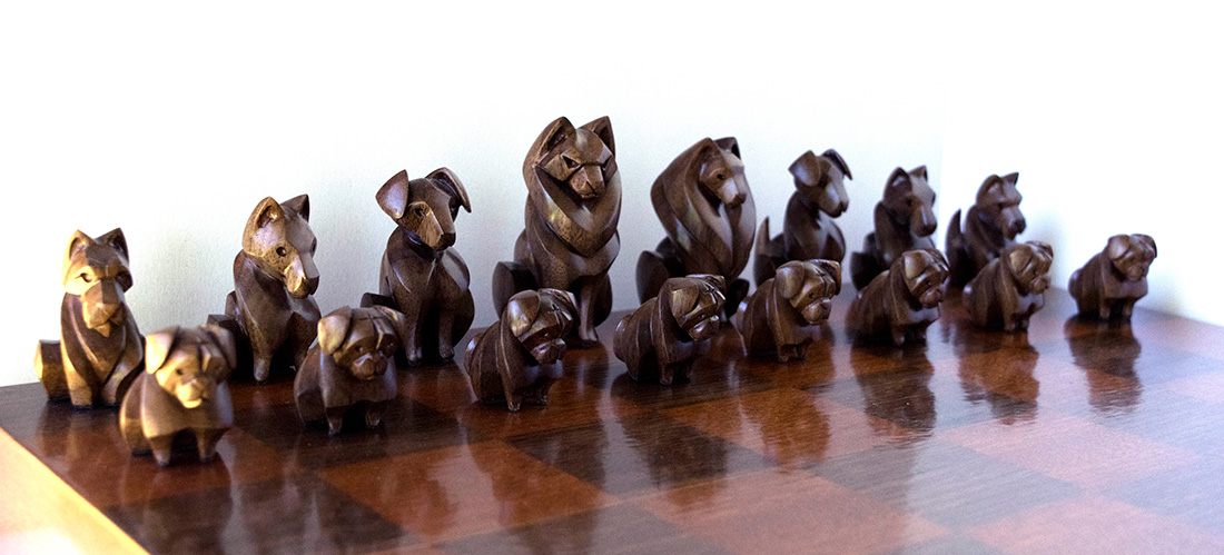 Canadian-based sculptor Patricia Aitkenhead’s carved animals make popular pendants and totems. But her business started with a classic debate: cats or dogs? As a way to settle the issue, she crafted a chess set comprised of a team of cats and a team of dogs. She chose breeds with traits she thought might fit their position on the board. Here, these pugs are the pawns.