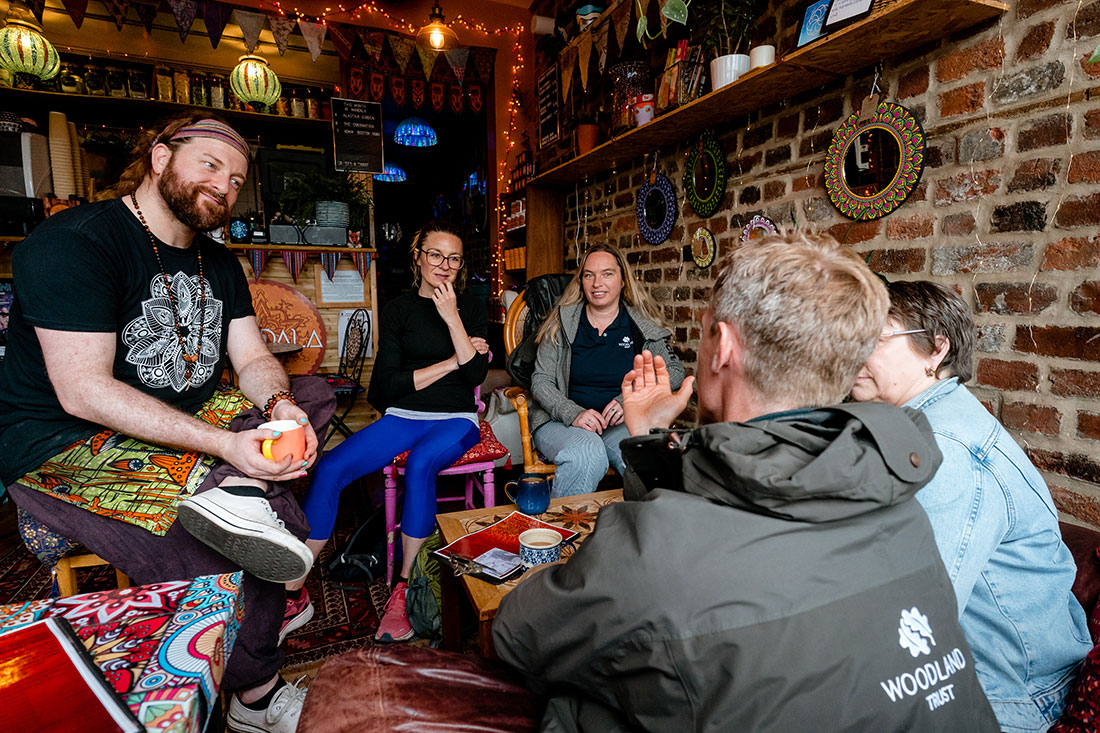 Cormack (foreground) discusses the potential of Tree Equity with the owner and patrons of Mandala Café — (from L to R) owner Adam Heyes, local resident Jennifer Foster, Catherine Nuttgens with the Woodland Trust and Dixon.
