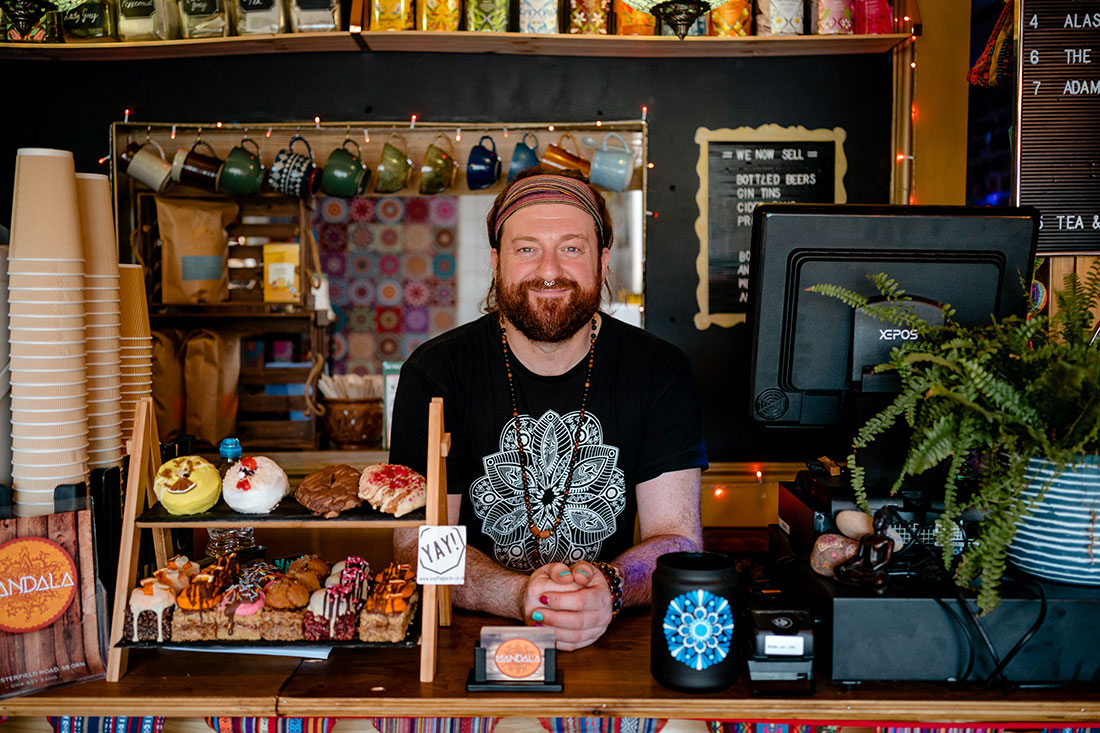 Heyes behind the counter of Mandala Café. “I do think trees are massively vital and integral in the role that they play to make people feel better and to just make everything nicer,” he says. “Because the world at the moment isn’t always that nice.”