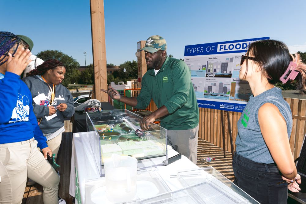 Students observe a flood-mitigation demonstration performed by the Department of Energy and Environment. Jada M Imani / American Forests