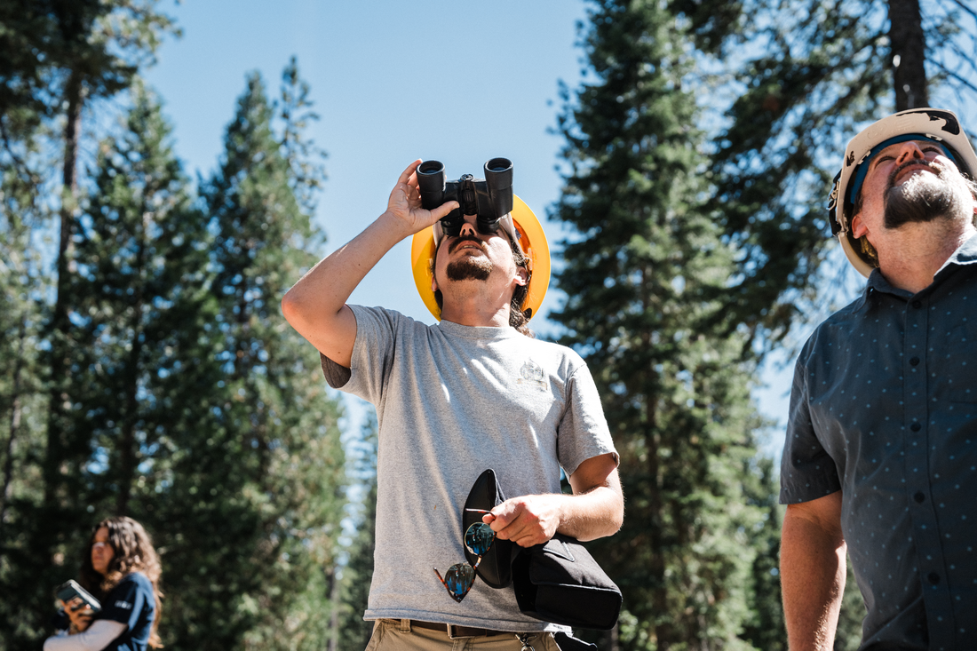 Attendee looking through binoculars during fieldwork Cone Camp 2024 CREATOR Leon Villagomez Leon Villagomez
