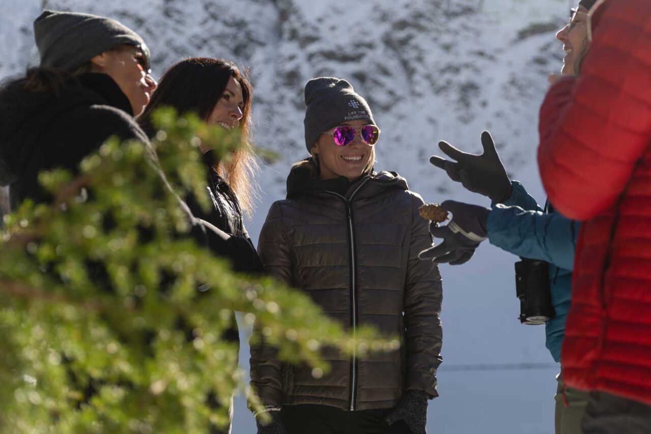 Pansing shows a whitebark pine cone and details the season's success to Life Time Foundation representatives, including (from L to R) Valeria La Rosa, program director; Sarah Emola, senior director; and Powell.